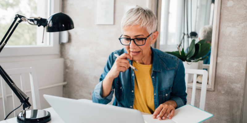 Mature women looking at her laptop thinking