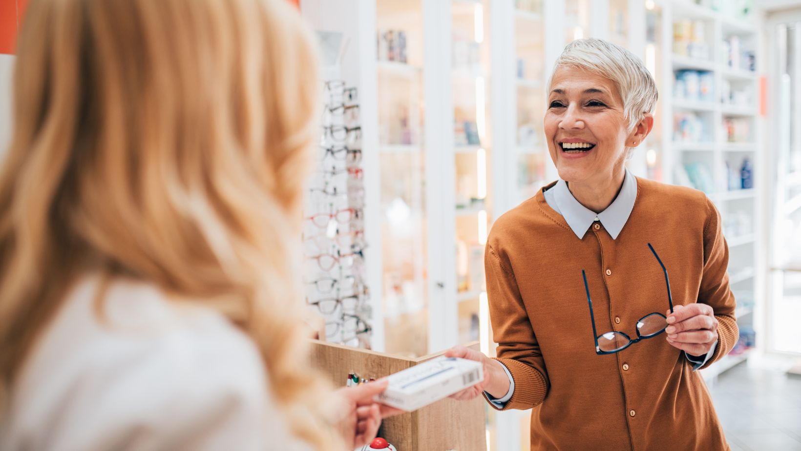 Woman handing over a prescription to another woman 