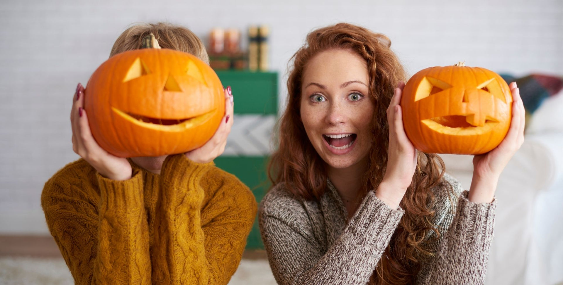 Happy people holding pumpkins to their heads
