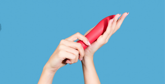 Hands holding a vibrator up to illustrate the history of vibrators