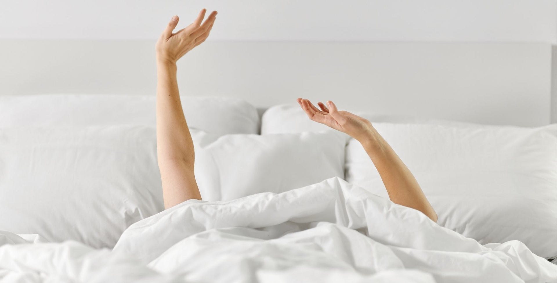 Excited hands sticking up from bedsheets