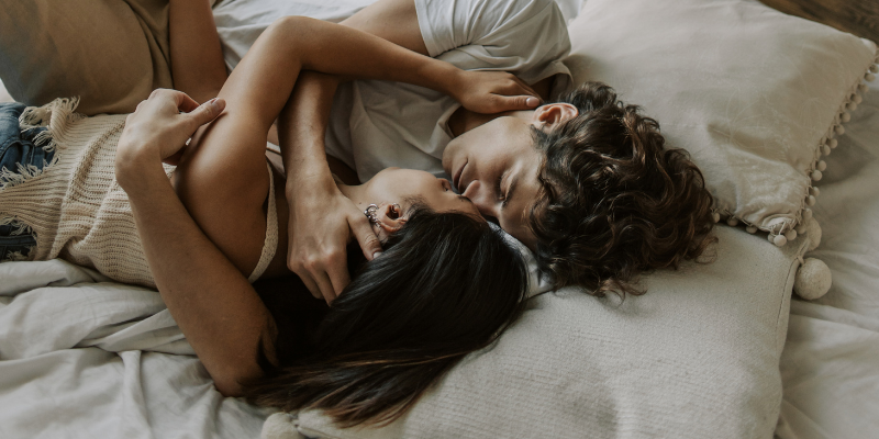 Couple lying on bed embracing