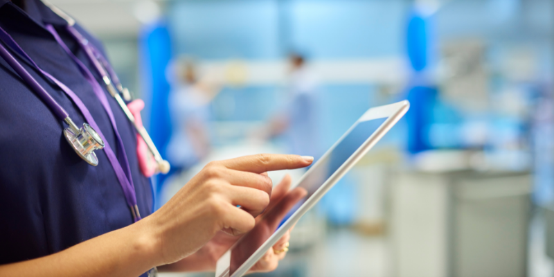 NHS worker types on tablet