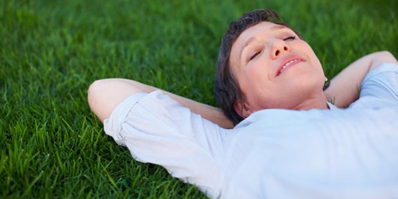 Menopausal woman lying in grass