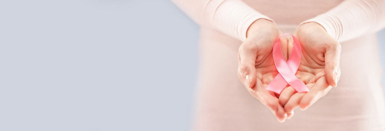woman holding her hands out with a pink cancer ribbon in her palms 