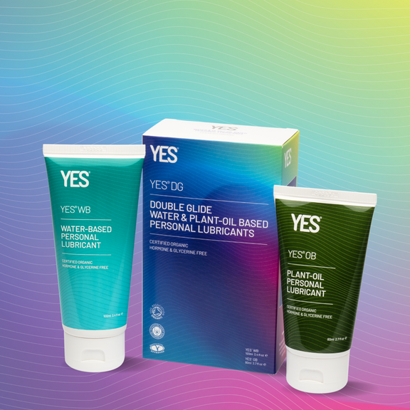 Carton of YES double glide next to a tube of YES WB and YES OB.  On a rainbow background with fine contour lines running across the image.